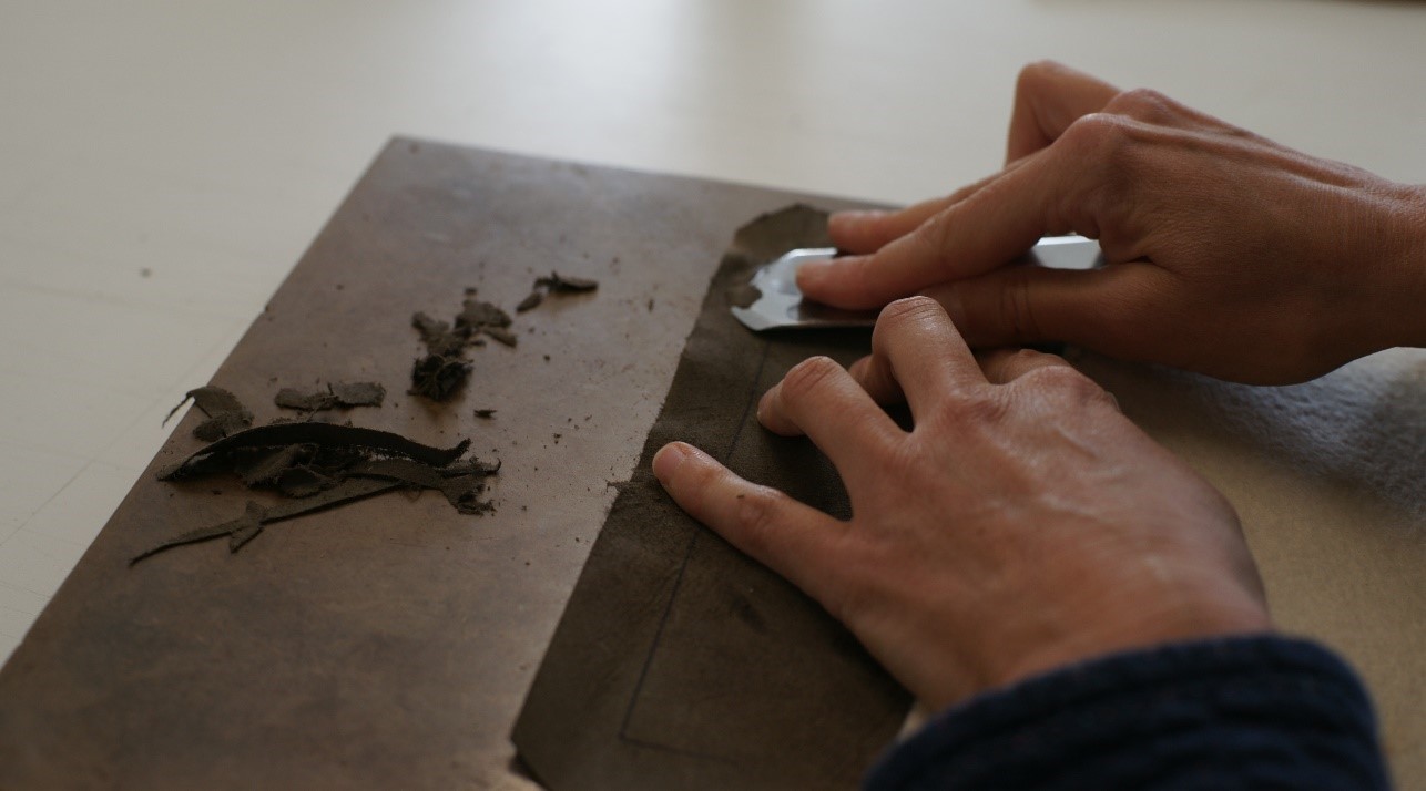 Préparation de la couverture en cuir pour son application sur le manuscrit restauré